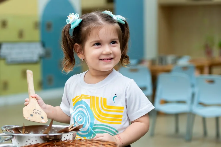 Criança da Educação Infantil explorando sons em atividade na escola