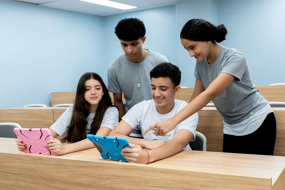 Estudantes da Escola Crescimento aprendendo juntos com tablets